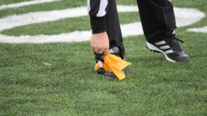 Referee picking up a flag on a football field