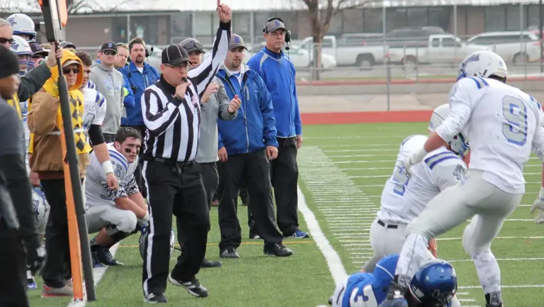 Head linesman blowing the whistle on a football field