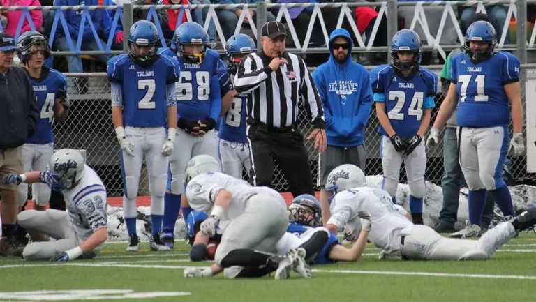 Football official blowing whistle