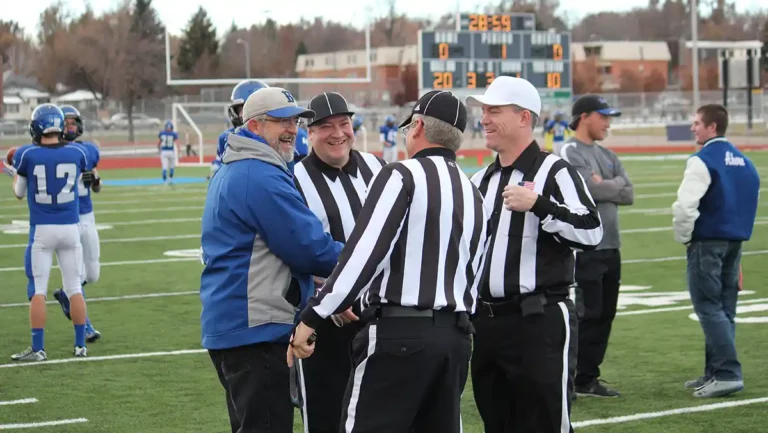 Officials meeting with the coach before the game